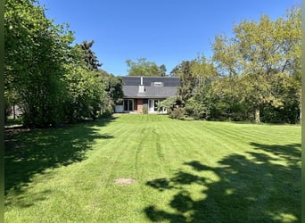 Spacious country house with equestrian facilities, riding arena, and a stunning park-like garden in 
